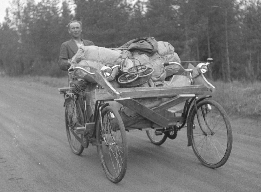 Kuvassa on mies polkupyöränä toimivilla evakkokärryillä.